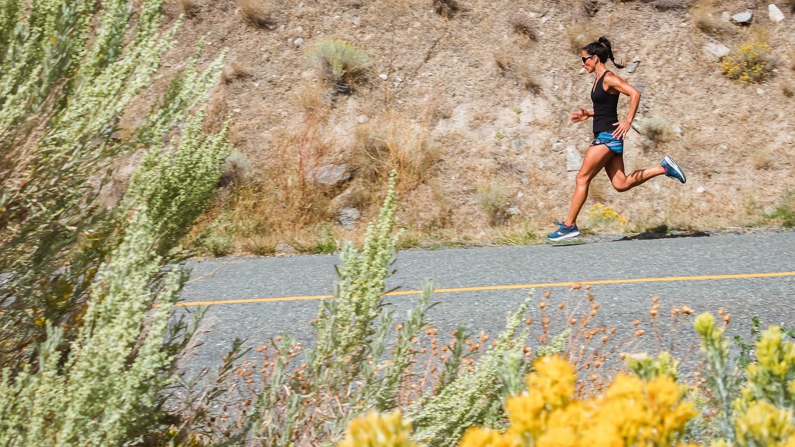 Coureur regardant sa montre GPS pendant un entraînement sur route, gestion de l'allure