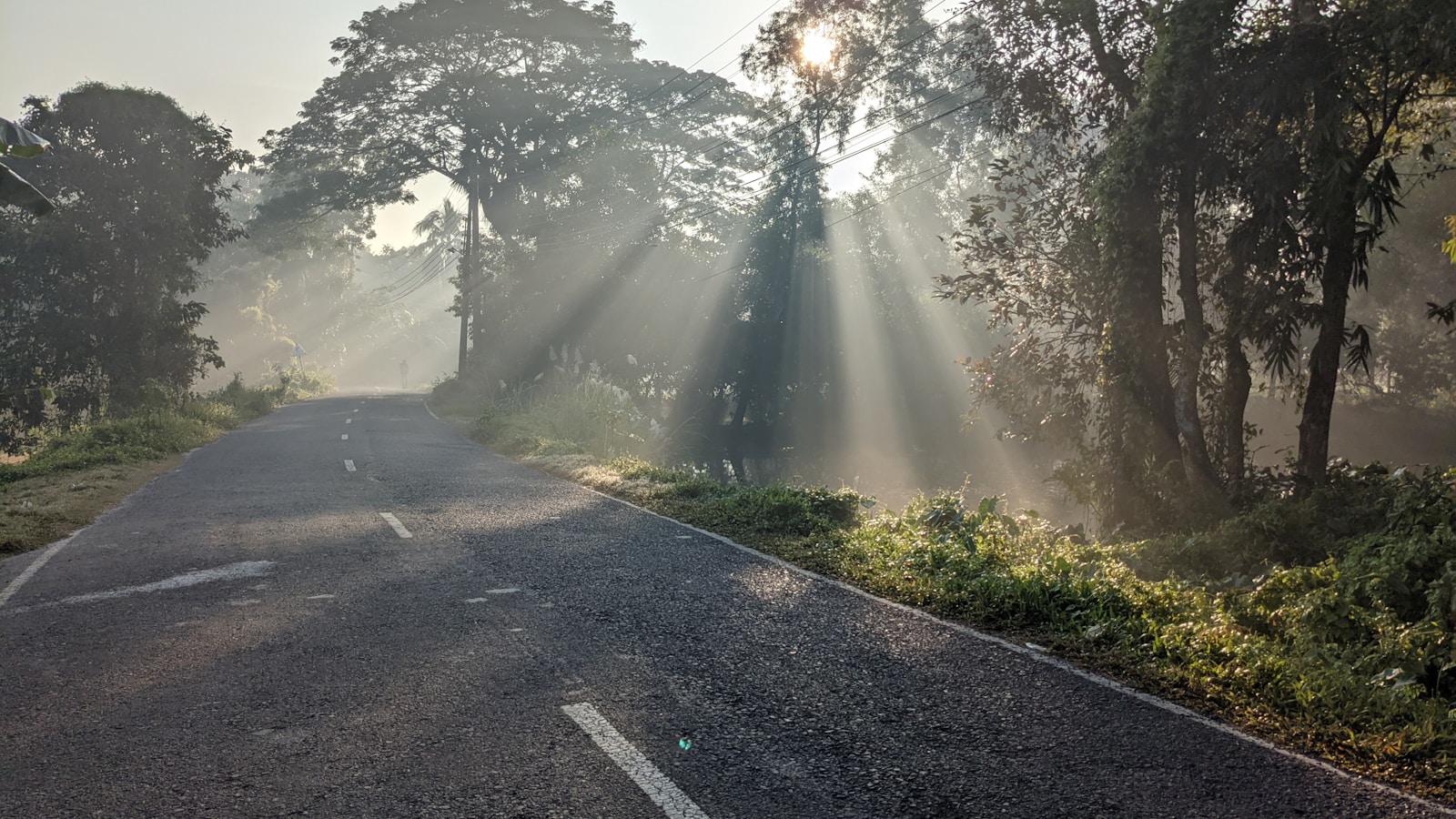 Route de campagne au lever du soleil avec rayons de lumière, invitation à débuter la course à pied