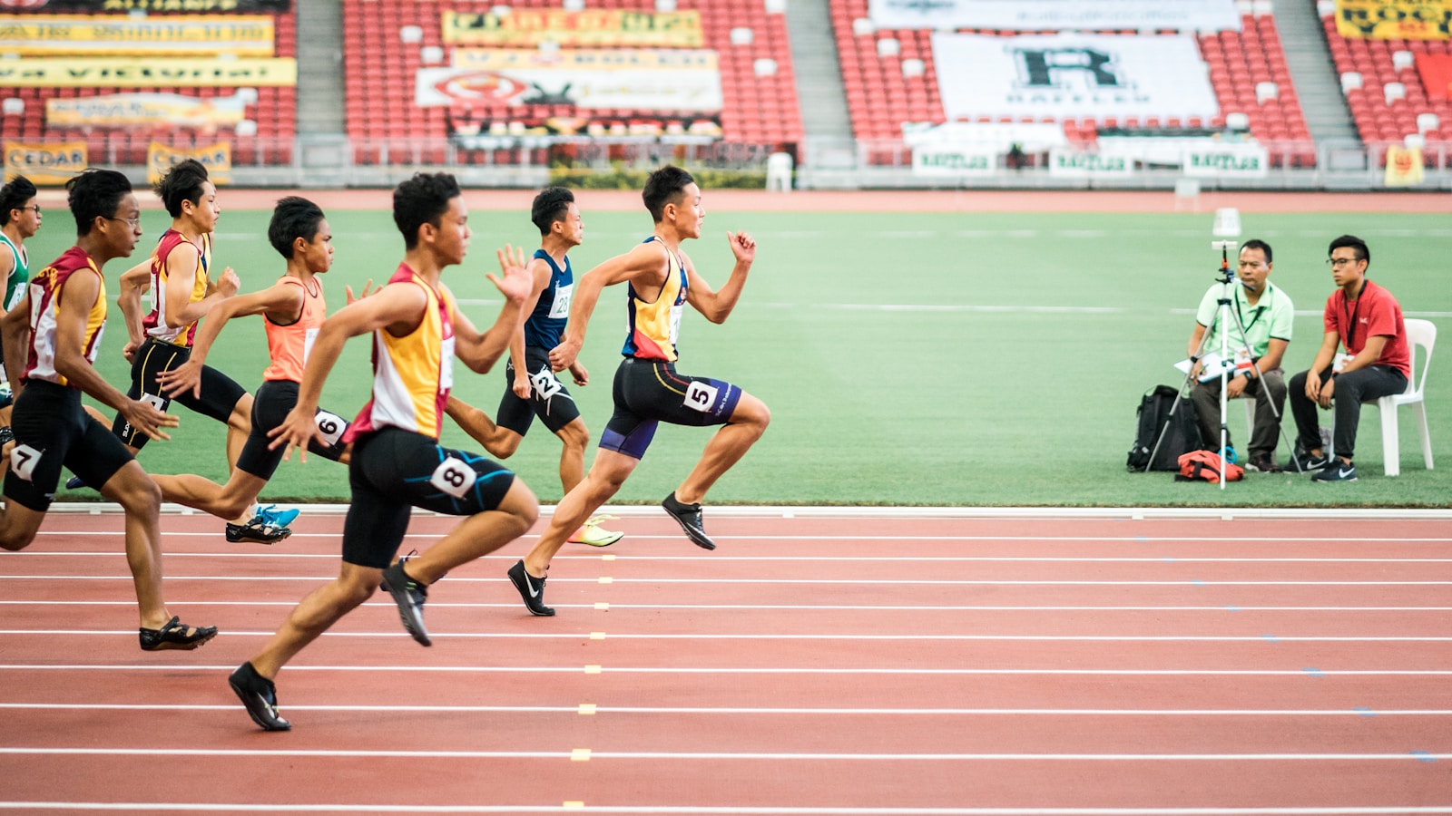Coureurs lancés à pleine vitesse sur une piste d'athlétisme, illustration d'une séance de fractionné